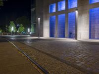 the people are sitting on bikes in front of blue windows and stone bricks are illuminated