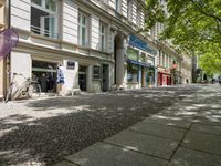 a restaurant in the middle of a narrow city street with graffiti on the wall and the sidewalk outside the building