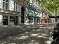 a restaurant in the middle of a narrow city street with graffiti on the wall and the sidewalk outside the building