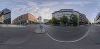 a fish eye view of a street in a city, which has buildings, cars, and some other buildings