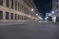 an empty street with tall buildings in the background at night time's most visible light