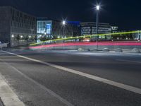 large building on the street with lights in front and other buildings nearby at night with no one moving