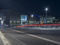 large building on the street with lights in front and other buildings nearby at night with no one moving