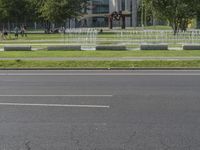 a man riding a skateboard on a sidewalk next to a fountain and trees area