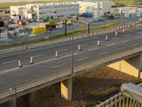 a freeway bridge is being built next to a building site and workers are at the top