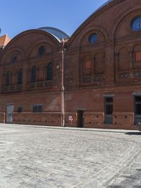 a man is using a cellphone in an open courtyard area in a building with red brick walls