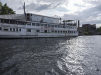 large body of water next to a building near the river with people on it and boats in the water
