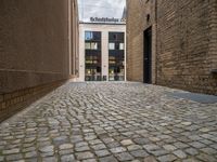 a sidewalk that has bricks on it in front of a building with an open door