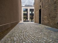 a sidewalk that has bricks on it in front of a building with an open door