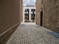 a sidewalk that has bricks on it in front of a building with an open door