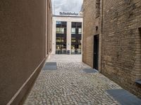 a sidewalk that has bricks on it in front of a building with an open door