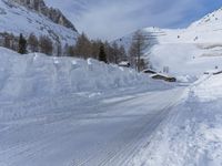 there are many piles of snow that have been piled up on this hill side on a ski slope