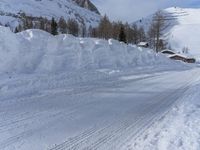 there are many piles of snow that have been piled up on this hill side on a ski slope