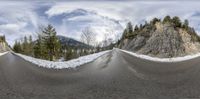 an alpine mountain with two roads in front and snow capped trees all around it as the lens is out and there is not a shadow or one person