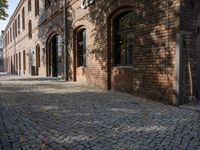 a brick building with windows on the outside and an old fashioned door behind it on the right