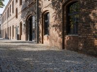 a brick building with windows on the outside and an old fashioned door behind it on the right