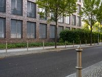 a street sign on a pole in front of some building with trees near the road