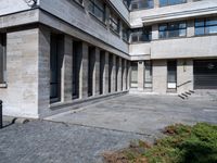 the building contains a lot of windows and steps leading to them, all with windows open