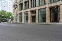 an empty city street with tall buildings and large windows in the background - this picture shows the outside of the building and the street