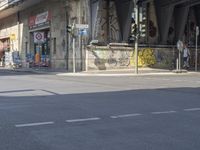 an old man in yellow shirt sitting on bike on side of road with graffiti underpass