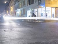 cars and pedestrians make their way down a street in a city at night time in europe