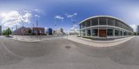 a 360 view lens looking at a view of an empty street and buildings in the background