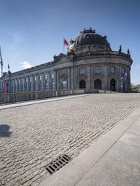 a courtyard outside of a museum with a manhole at the base of it and some spires on the building