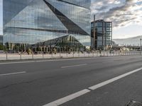 a street in front of a building that has multiple glass on it and it looks nice