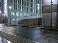 an open area outside of a building in the rain with an umbrella on the side