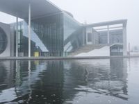 the water surface is very calm, as seen in front of the modern looking building