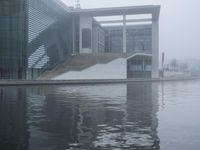 the water surface is very calm, as seen in front of the modern looking building