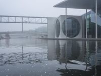 the water surface is very calm, as seen in front of the modern looking building