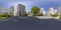 a panoramic view of the skate park, with buildings in the background and a ramp on one side