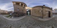 a fish eye view of a circular building in a town square with people in the distance