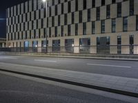 the building next to the street is lit up with lights and traffic signs as the person walks