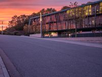 the sunset shines brightly in front of a building and street with steps leading up to it