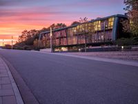 the sunset shines brightly in front of a building and street with steps leading up to it