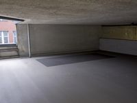 empty room with floor and window in large building next to stairs and building in background