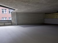 empty room with floor and window in large building next to stairs and building in background