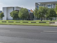 street view of an empty city with buildings in the background and a parked car on the curb