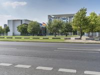 street view of an empty city with buildings in the background and a parked car on the curb