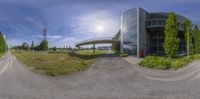 a 360 - degree panoramic photo shows a curved road going to a building