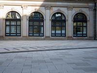 a large building with a lot of windows in it's middle part and some bricks on the ground