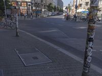 the street is lined with several buildings and street signs and a drain cover on the side