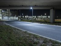 a road with some lights near a highway side at night time by a construction structure