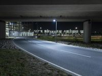 a road with some lights near a highway side at night time by a construction structure