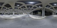 a reflection view of a large parking garage with curved arches, black ceiling, and cars