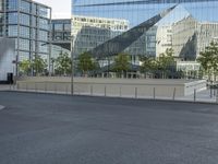 two city buildings reflected in a curved glass windowed building, from the street with no cars