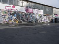 a photo of a city street with a bunch of graffitti on a wall