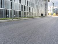 a motorcycle parked on the side of a street in front of a tall building with glass windows